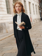 a lady in black triacetate lace-up trench coat